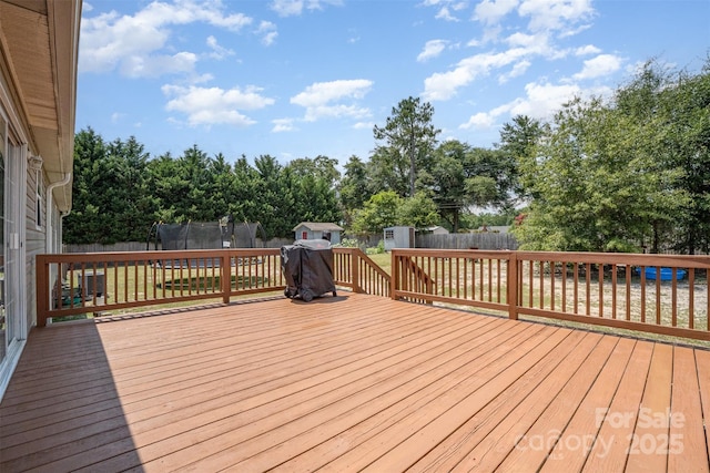 108 W Welsh St, Kershaw, SC 29067 - wooden deck with a storage shed, a trampoline, a fenced backyard, and view of wooded area