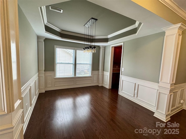 12517 Pine Terrace Ct, Charlotte, NC 28273 - unfurnished room with a raised ceiling, decorative columns, a decorative wall, dark wood-style flooring, and crown molding