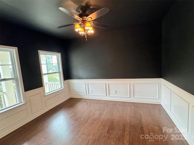 12517 Pine Terrace Ct, Charlotte, NC 28273 - empty room featuring wood finished floors, wainscoting, a ceiling fan, and a decorative wall