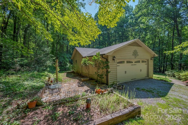 144 Beechwood Dr, Columbus, NC 28722 - garage with gravel driveway and a wooded view