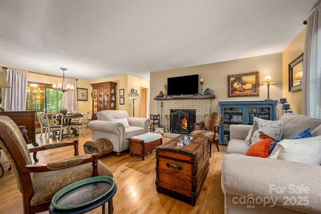 144 Beechwood Dr, Columbus, NC 28722 - living room featuring a chandelier, light wood-style flooring, and a brick fireplace