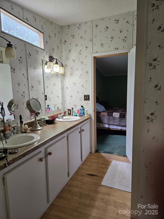 245 Waycross Dr, Rockwell, NC 28138 - full bathroom featuring wallpapered walls, double vanity, wood finished floors, a textured ceiling, and ensuite bath