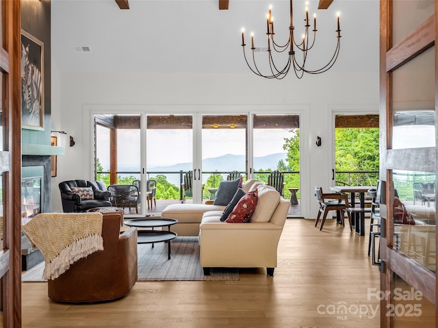 627 Cherry Hl Unit 201, Mill Spring, NC 28756 - living room with high vaulted ceiling, a glass covered fireplace, a mountain view, wood finished floors, and a ceiling fan