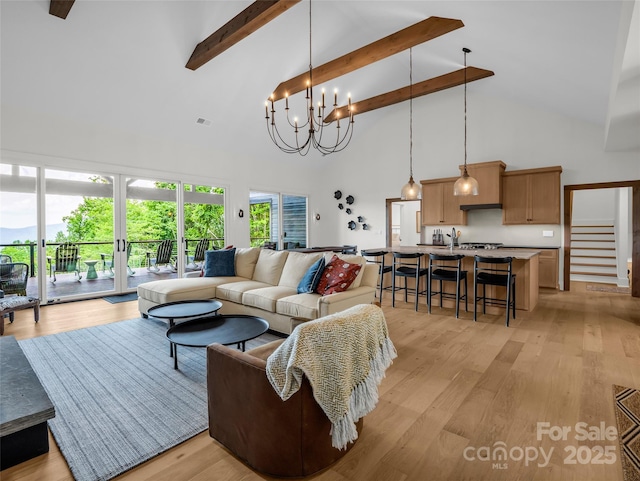 627 Cherry Hl Unit 201, Mill Spring, NC 28756 - living room featuring high vaulted ceiling, beamed ceiling, light wood-type flooring, stairway, and a chandelier