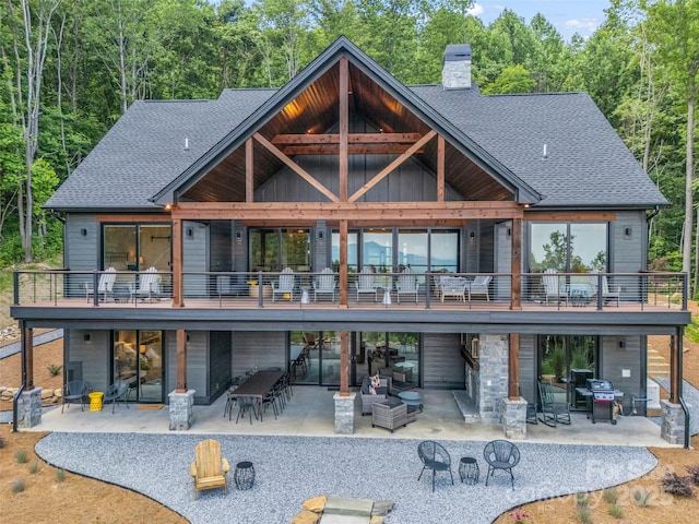 627 Cherry Hl Unit 201, Mill Spring, NC 28756 - back of house with a patio area, a chimney, an outdoor living space, board and batten siding, and roof with shingles