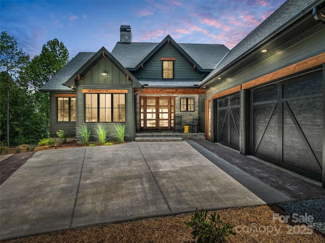 627 Cherry Hl Unit 201, Mill Spring, NC 28756 - view of front of home with a chimney, a shingled roof, a garage, board and batten siding, and a standing seam roof