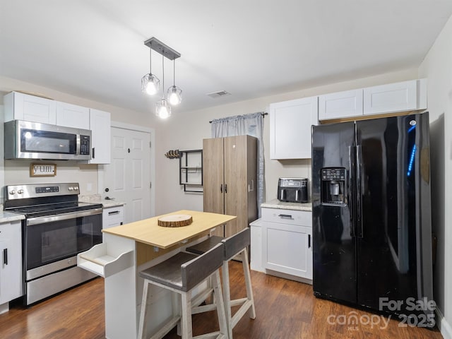 206 Friedheim Rd, Rock Hill, SC 29730 - kitchen featuring stainless steel appliances, white cabinets, decorative light fixtures, and dark wood-style flooring