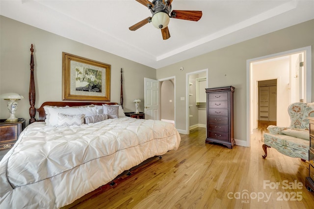 80 Meadow Creek Drive 40 & 61, Weaverville, NC 28787 - bedroom with a tray ceiling, light wood-style flooring, a walk in closet, ceiling fan, and connected bathroom