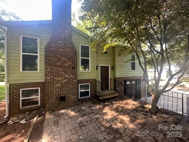 3211 Winding Trl, Matthews, NC 28105 - rear view of property with brick siding, a chimney, and a patio