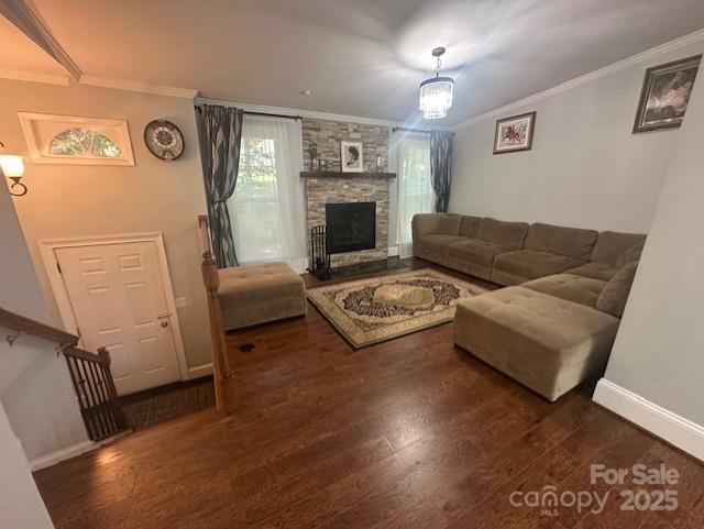 3211 Winding Trl, Matthews, NC 28105 - living room featuring crown molding, wood finished floors, and a stone fireplace