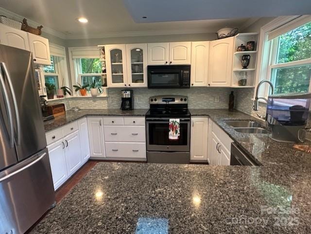 3211 Winding Trl, Matthews, NC 28105 - kitchen featuring appliances with stainless steel finishes, dark stone countertops, white cabinets, decorative backsplash, and ornamental molding