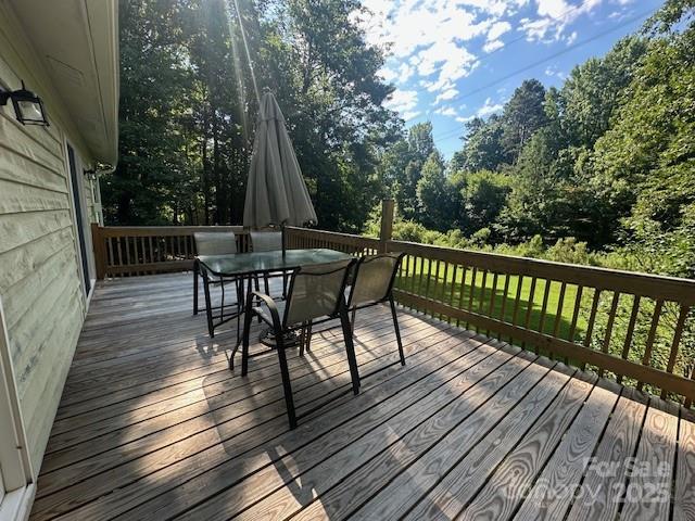 3211 Winding Trl, Matthews, NC 28105 - wooden deck featuring outdoor dining area and view of wooded area