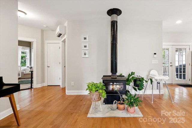 275 Haynes Dr, Salisbury, NC 28146 - living area featuring a wood stove, a wall mounted AC, light wood-type flooring, and french doors