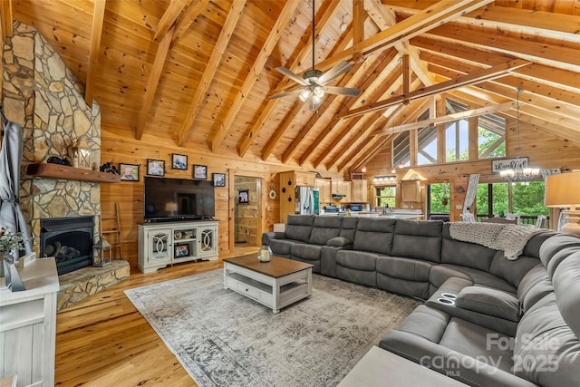 279 Outback Trl, Nebo, NC 28761 - living area with light wood-style flooring, a stone fireplace, wooden walls, a chandelier, and high vaulted ceiling