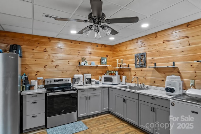 279 Outback Trl, Nebo, NC 28761 - kitchen featuring stainless steel appliances, gray cabinets, a ceiling fan, light wood finished floors, and wood walls