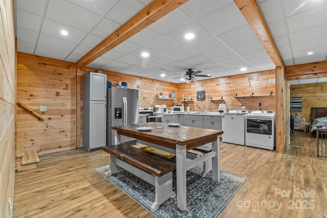 279 Outback Trl, Nebo, NC 28761 - kitchen featuring independent washer and dryer, stainless steel appliances, wooden walls, light wood-style floors, and a ceiling fan