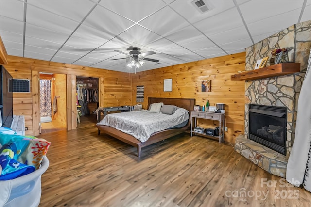 279 Outback Trl, Nebo, NC 28761 - bedroom featuring wood finished floors, a closet, wooden walls, a fireplace, and a ceiling fan