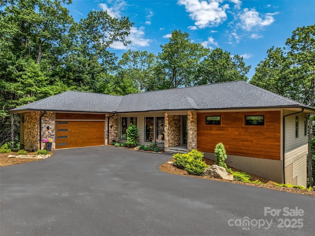 23 Haverhill Ct, Flat Rock, NC 28731 - view of front facade featuring an attached garage, driveway, a shingled roof, and stone siding