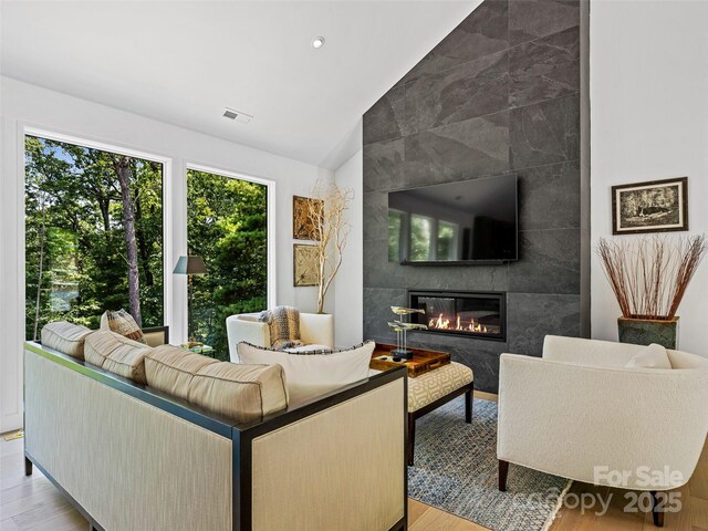 23 Haverhill Ct, Flat Rock, NC 28731 - living room featuring vaulted ceiling, wood finished floors, a tile fireplace, and recessed lighting