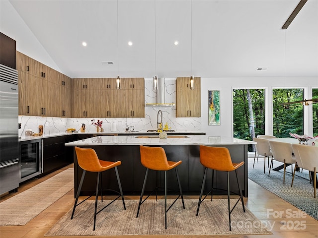23 Haverhill Ct, Flat Rock, NC 28731 - kitchen with wine cooler, exhaust hood, high end refrigerator, lofted ceiling, and tasteful backsplash