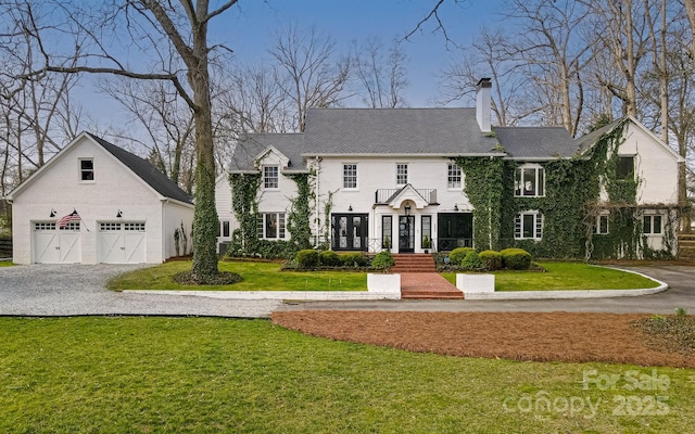 3306 Gaston Rd, Greensboro, NC 27407 - view of front of property featuring french doors, a front lawn, a chimney, and gravel driveway