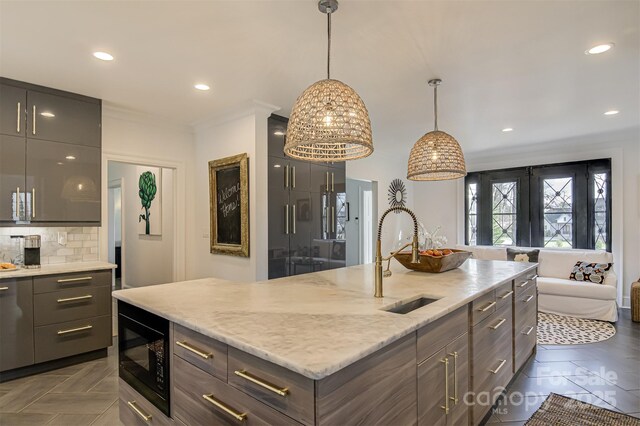 3306 Gaston Rd, Greensboro, NC 27407 - kitchen featuring black microwave, a kitchen island with sink, recessed lighting, decorative backsplash, and light stone countertops