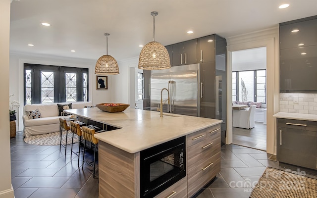 3306 Gaston Rd, Greensboro, NC 27407 - kitchen with built in appliances, gray cabinetry, dark tile patterned floors, a kitchen bar, and crown molding