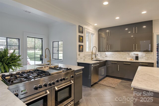 3306 Gaston Rd, Greensboro, NC 27407 - kitchen featuring appliances with stainless steel finishes, light countertops, recessed lighting, decorative backsplash, and modern cabinets