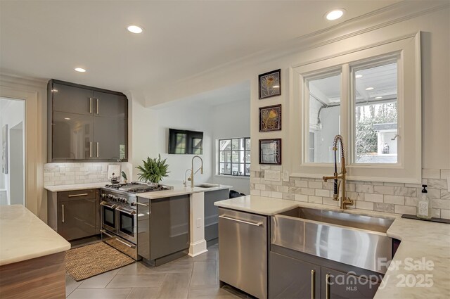 3306 Gaston Rd, Greensboro, NC 27407 - kitchen featuring appliances with stainless steel finishes, light countertops, recessed lighting, decorative backsplash, and a peninsula
