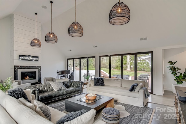 3306 Gaston Rd, Greensboro, NC 27407 - living room with high vaulted ceiling, wood finished floors, and a fireplace