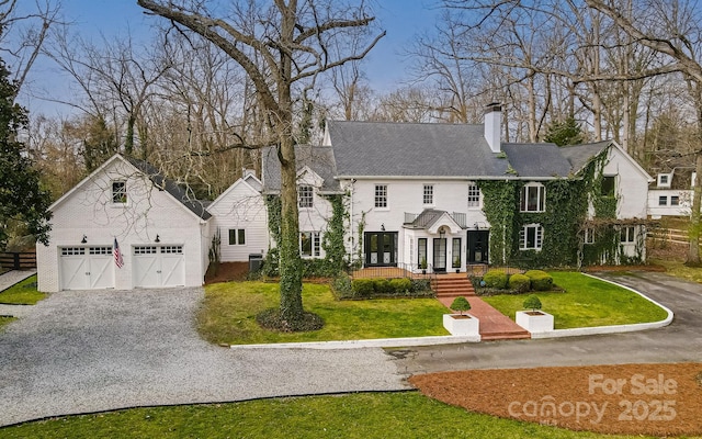 3306 Gaston Rd, Greensboro, NC 27407 - view of front of property with a chimney, gravel driveway, a front lawn, and an outdoor structure