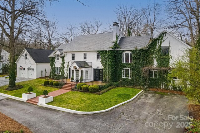 3306 Gaston Rd, Greensboro, NC 27407 - view of front facade featuring a chimney, an outdoor structure, a front yard, and a garage