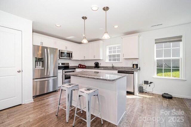 1026 Baileys Chapel Rd, Advance, NC 27006 - kitchen featuring stainless steel appliances, light wood-type flooring, a kitchen island, a breakfast bar, and recessed lighting