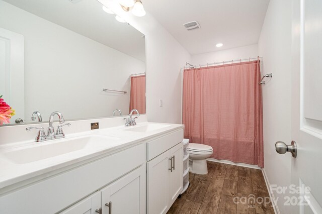 1026 Baileys Chapel Rd, Advance, NC 27006 - bathroom featuring double vanity, wood finished floors, and recessed lighting