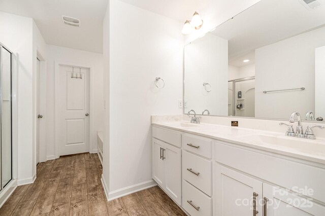 1026 Baileys Chapel Rd, Advance, NC 27006 - bathroom featuring a shower with shower door, wood finished floors, double vanity, and a bathtub