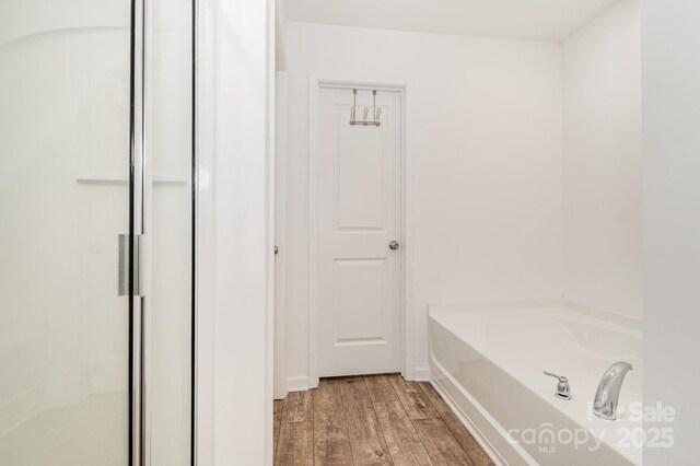 1026 Baileys Chapel Rd, Advance, NC 27006 - full bathroom with wood finished floors, a bath, and a stall shower