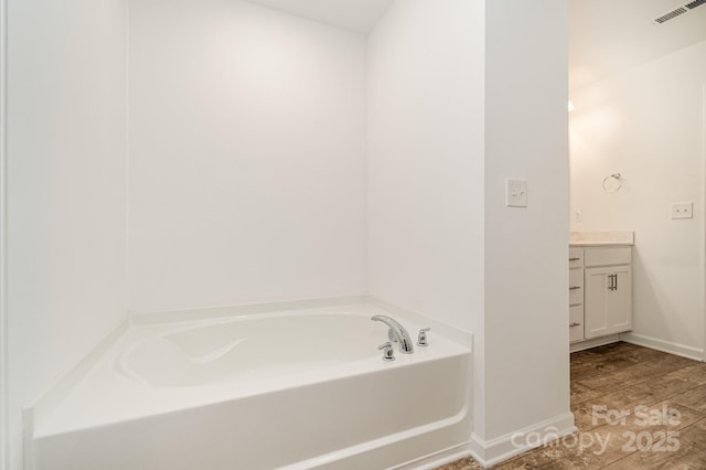 1026 Baileys Chapel Rd, Advance, NC 27006 - bathroom featuring vanity, a garden tub, and wood finished floors