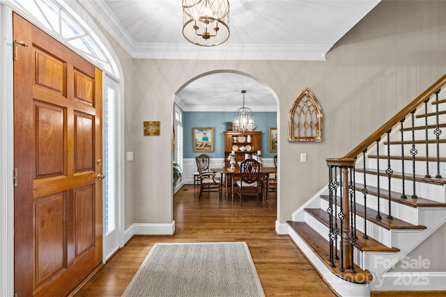 6716 Southby Ct, Charlotte, NC 28270 - entrance foyer featuring a chandelier, arched walkways, stairs, wood finished floors, and ornamental molding