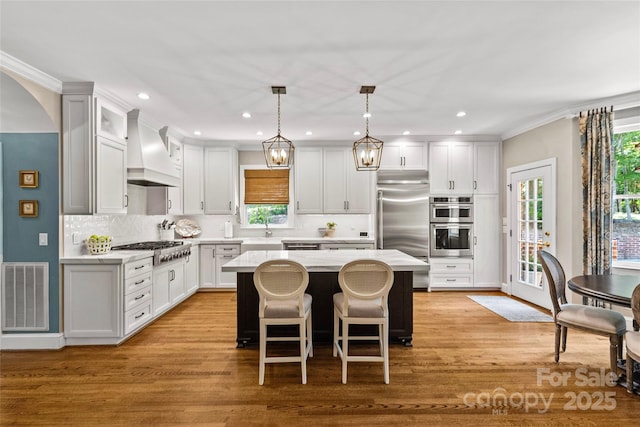 6716 Southby Ct, Charlotte, NC 28270 - kitchen with custom exhaust hood, stainless steel appliances, a kitchen island, light countertops, and decorative backsplash