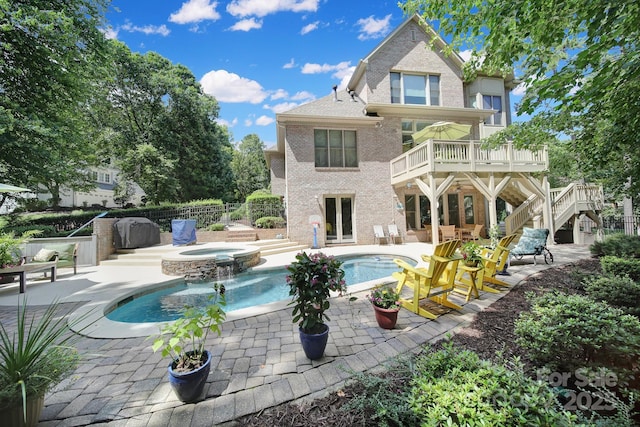 166 Atlantic Way, Mooresville, NC 28117 - back of property featuring brick siding, stairs, a pool with connected hot tub, a patio area, and a balcony