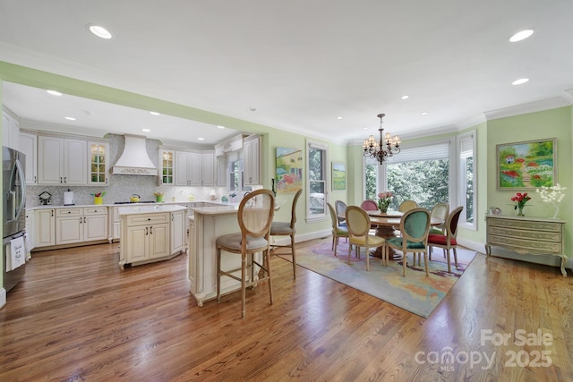 166 Atlantic Way, Mooresville, NC 28117 - kitchen featuring premium range hood, a center island, light countertops, a kitchen bar, and wood finished floors