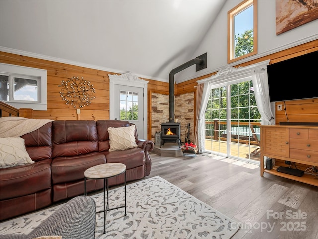 334 Arbra Mountain Way, Bostic, NC 28018 - living room featuring high vaulted ceiling, a wood stove, healthy amount of natural light, wood finished floors, and wooden walls