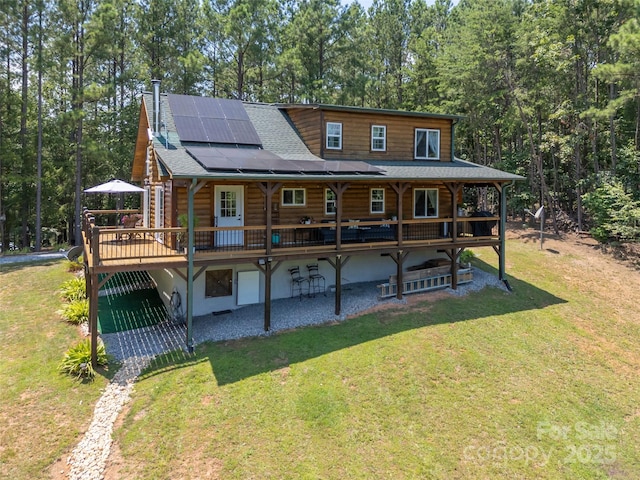 334 Arbra Mountain Way, Bostic, NC 28018 - rear view of house featuring a lawn, roof mounted solar panels, a deck, roof with shingles, and log siding