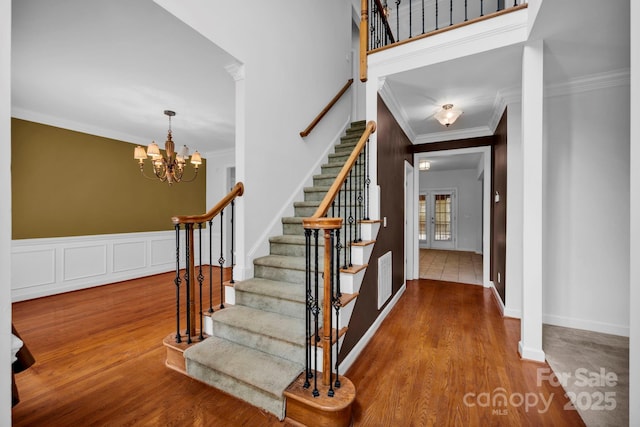 5138 Foxbriar Trl, Charlotte, NC 28269 - staircase with crown molding, wood finished floors, and a chandelier