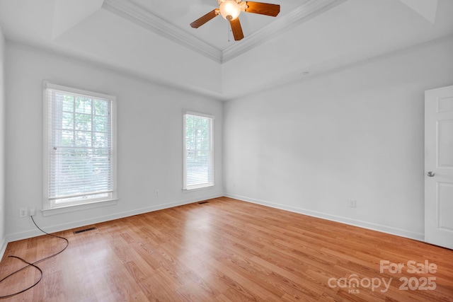 5138 Foxbriar Trl, Charlotte, NC 28269 - empty room featuring a raised ceiling, crown molding, light wood-style flooring, and ceiling fan