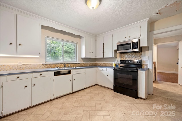 7010 Monroe Rd, Charlotte, NC 28212 - kitchen featuring stainless steel microwave, black electric range, white cabinets, a textured ceiling, and tasteful backsplash
