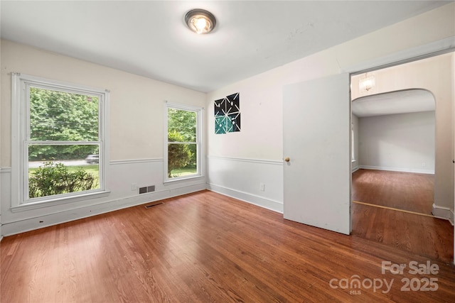 7010 Monroe Rd, Charlotte, NC 28212 - spare room featuring arched walkways and wood finished floors
