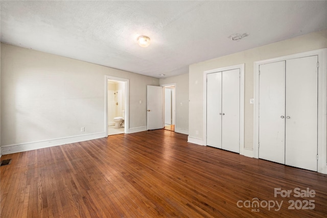 7010 Monroe Rd, Charlotte, NC 28212 - unfurnished bedroom with multiple closets, wood finished floors, and ensuite bathroom