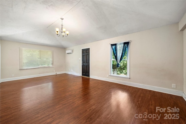 7010 Monroe Rd, Charlotte, NC 28212 - spare room with a chandelier, a wall mounted air conditioner, wood finished floors, and vaulted ceiling