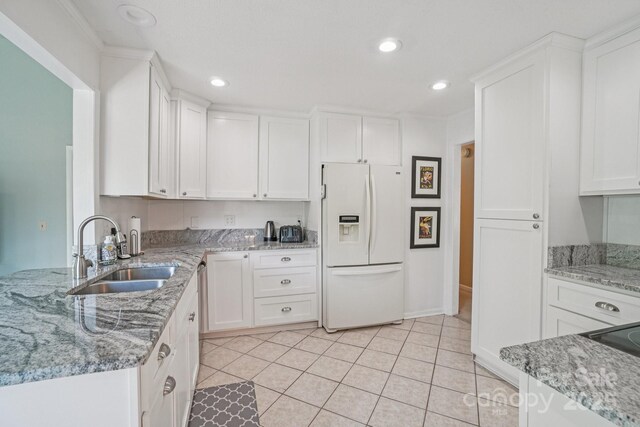 25 Hazel Ct, Brevard, NC 28712 - kitchen with white fridge with ice dispenser, white cabinetry, recessed lighting, light stone counters, and light tile patterned floors